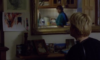 Movie still from “Ladybird Ladybird” (1994), directed by Ken Loach – A woman sitting in front of a mirror in a room; Medium shot, Over the shoulder angle