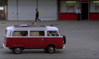 Movie still from “Ladybird Ladybird” (1994), directed by Ken Loach – A red and white van parked on the side of the road; Wide shot, High angle