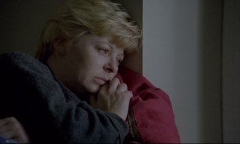 Movie still from “Ladybird Ladybird” (1994), directed by Ken Loach – A woman sitting on a couch with her head resting on a pillow; Close Up shot, High angle