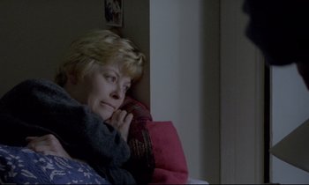 Movie still from “Ladybird Ladybird” (1994), directed by Ken Loach – A woman sitting on a couch with her hand on her chin; Close Up shot, Over the shoulder angle