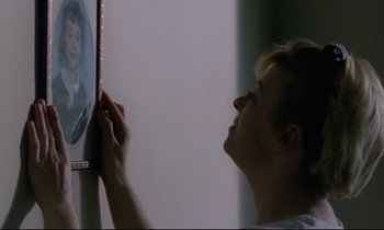Movie still from “Ladybird Ladybird” (1994), directed by Ken Loach – A woman looking at a picture on a wall; Extreme Close Up shot, Over the shoulder angle