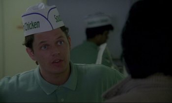 Movie still from “Ladybird Ladybird” (1994), directed by Ken Loach – A man wearing a green shirt and a white paper hat; Close Up shot, Over the shoulder angle