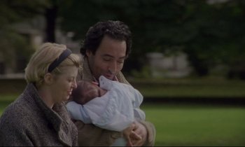 Movie still from “Ladybird Ladybird” (1994), directed by Ken Loach – A man and woman holding a baby in his arms; Close Up shot, Low angle