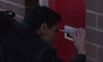 Movie still from “Ladybird Ladybird” (1994), directed by Ken Loach – A young man looking into a red door; Close Up shot, Low angle