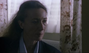 Movie still from “Ladybird Ladybird” (1994), directed by Ken Loach – A person wearing a suit and tie; Close Up shot, Over the shoulder angle