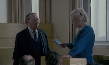 Movie still from “Ladybird Ladybird” (1994), directed by Ken Loach – An older man and a woman in a room; Medium shot, High angle