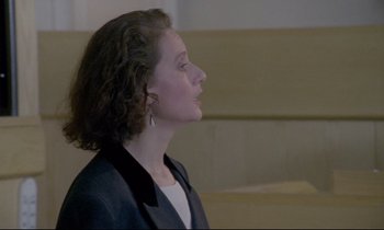 Movie still from “Ladybird Ladybird” (1994), directed by Ken Loach – A woman in a black jacket is looking to the side; Close Up shot, Low angle