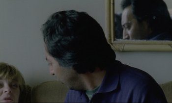 Movie still from “Ladybird Ladybird” (1994), directed by Ken Loach – A man sitting in front of a mirror looking at himself in the mirror; Close Up shot, Over the shoulder angle