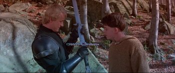 Movie still from “Ladyhawke” (1985), directed by Richard Donner – Two men are holding swords in a forest; Medium shot, High angle