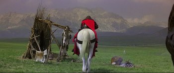 Movie still from “Ladyhawke” (1985), directed by Richard Donner – A man riding on the back of a white horse; Wide shot, Low angle