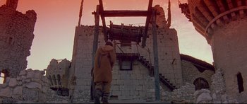 Movie still from “Ladyhawke” (1985), directed by Richard Donner – A man walking up a stone staircase in the sunset; Wide shot, Low angle
