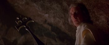 Movie still from “Ladyhawke” (1985), directed by Richard Donner – An old man in a cave holding an object; Close Up shot, Low angle