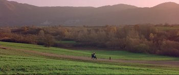 Movie still from “Ladyhawke” (1985), directed by Richard Donner – Two people riding horses in a green field; Extreme Wide shot, High angle