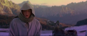 Movie still from “Ladyhawke” (1985), directed by Richard Donner – A young boy wearing a hooded jacket and a scarf; Medium shot, Low angle