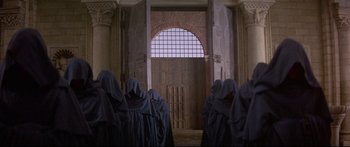Movie still from “Ladyhawke” (1985), directed by Richard Donner – A group of people standing in front of an archway; Wide shot, High angle