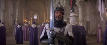 Movie still from “Ladyhawke” (1985), directed by Richard Donner – A man dressed as a medieval knight holding a sword; Medium shot, Low angle