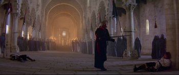 Movie still from “Ladyhawke” (1985), directed by Richard Donner – A man in a black robe holding a sword; Wide shot, High angle