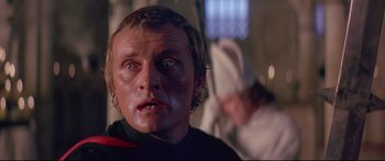 Movie still from “Ladyhawke” (1985), directed by Richard Donner – A person with blood on his face; Close Up shot, Low angle