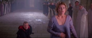 Movie still from “Ladyhawke” (1985), directed by Richard Donner – A woman standing in front of a group of people; Medium shot, Over the shoulder angle