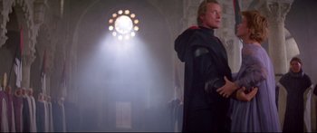 Movie still from “Ladyhawke” (1985), directed by Richard Donner – A man standing in front of a window with lights; Medium shot, Low angle