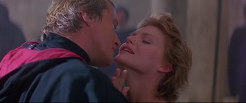 Movie still from “Ladyhawke” (1985), directed by Richard Donner – A man and a woman are kissing in a room; Close Up shot, Low angle