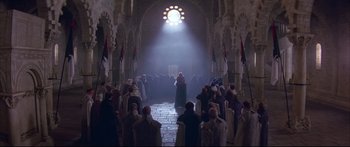 Movie still from “Ladyhawke” (1985), directed by Richard Donner – A group of people standing in front of a building; Extreme Wide shot, High angle
