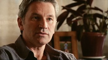 Movie still from “Lake Mungo” (2008), directed by Joel Anderson – A person wearing a gray shirt; Close Up shot, Over the shoulder angle