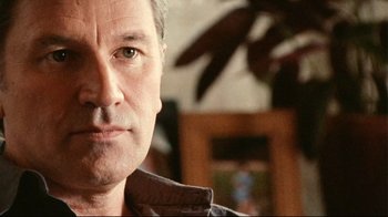 Movie still from “Lake Mungo” (2008), directed by Joel Anderson – A man's face in a living room; Close Up shot, Low angle