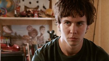 Movie still from “Lake Mungo” (2008), directed by Joel Anderson – A young man is looking into the camera; Close Up shot, Over the shoulder angle