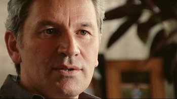 Movie still from “Lake Mungo” (2008), directed by Joel Anderson – A man's face in a living room setting; Close Up shot, Low angle