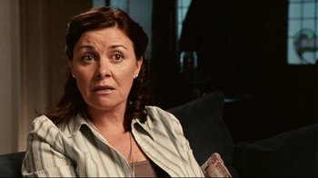 Movie still from “Lake Mungo” (2008), directed by Joel Anderson – A person sitting on a couch; Close Up shot, Over the shoulder angle