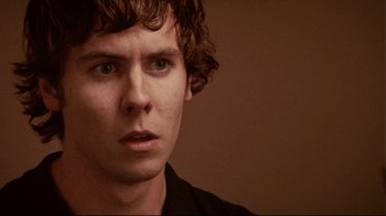 Movie still from “Lake Mungo” (2008), directed by Joel Anderson – A person wearing a black shirt; Close Up shot, Over the shoulder angle