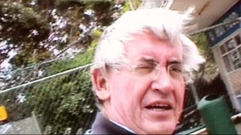Movie still from “Lake Mungo” (2008), directed by Joel Anderson – An older man with white hair and glasses is smiling; Extreme Close Up shot, Low angle