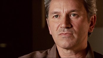 Movie still from “Lake Mungo” (2008), directed by Joel Anderson – A man's face in a dark room; Close Up shot, Low angle