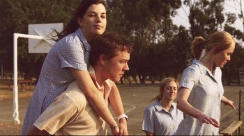Movie still from “Lake Mungo” (2008), directed by Joel Anderson – A man and a woman sitting on top of each other; Medium shot, Low angle