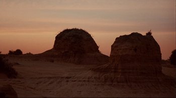 Movie still from “Lake Mungo” (2008), directed by Joel Anderson – A couple of rock formations in the middle of the desert; Extreme Wide shot, Low angle