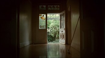 Movie still from “Lake Mungo” (2008), directed by Joel Anderson – A door way leading to a room with a view of a garden; Wide shot, Low angle