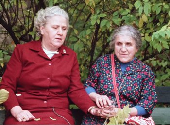 Movie still from “Land of Silence and Darkness” (1971), directed by Werner Herzog – Two older women sitting next to each other on a bench; Medium shot, High angle