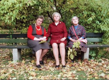 Movie still from “Land of Silence and Darkness” (1971), directed by Werner Herzog – A group of women sitting on top of a wooden bench; Wide shot, Low angle