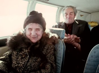 Movie still from “Land of Silence and Darkness” (1971), directed by Werner Herzog – An older woman sitting next to an older man on a plane; Medium shot, High angle
