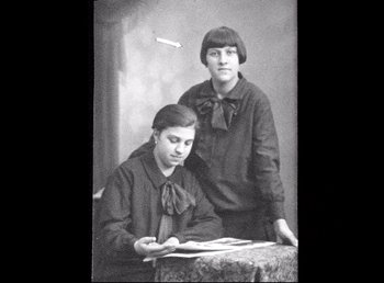 Movie still from “Land of Silence and Darkness” (1971), directed by Werner Herzog – A couple of people that are standing up in a room; Medium shot, Low angle