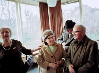 Movie still from “Land of Silence and Darkness” (1971), directed by Werner Herzog – An older man and a woman standing next to each other; Medium shot, High angle