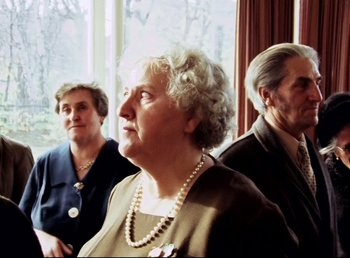 Movie still from “Land of Silence and Darkness” (1971), directed by Werner Herzog – A group of older people sitting next to each other in a room; Medium shot, Low angle