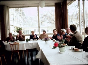 Movie still from “Land of Silence and Darkness” (1971), directed by Werner Herzog – A group of people sitting around a table; Wide shot, High angle