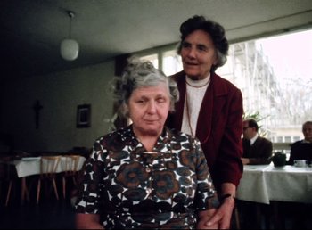 Movie still from “Land of Silence and Darkness” (1971), directed by Werner Herzog – Two older women are standing in a room; Medium shot, Over the shoulder angle