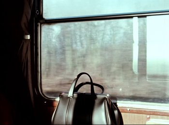 Movie still from “Land of Silence and Darkness” (1971), directed by Werner Herzog – A black purse sitting on top of a train; Medium shot, Low angle
