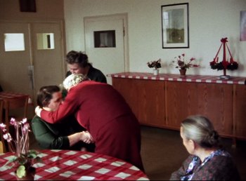 Movie still from “Land of Silence and Darkness” (1971), directed by Werner Herzog – A group of people gathered around a table; Wide shot, High angle