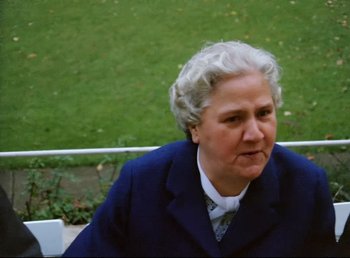 Movie still from “Land of Silence and Darkness” (1971), directed by Werner Herzog – An older woman sitting on top of a wooden bench; Close Up shot, High angle