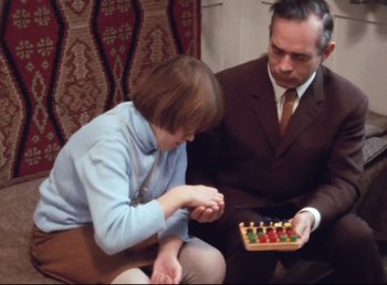 Movie still from “Land of Silence and Darkness” (1971), directed by Werner Herzog – A man and a woman are playing a game of checkers; Medium shot, Over the shoulder angle