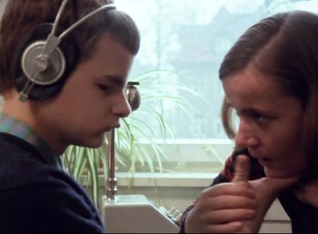 Movie still from “Land of Silence and Darkness” (1971), directed by Werner Herzog – A man and a woman wearing headphones and looking at each other; Close Up shot, Over the shoulder angle